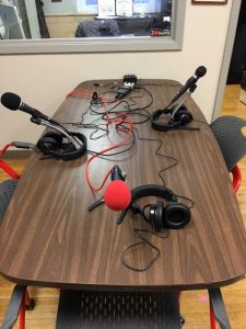 Podcasting table with microphones, H5 recorder, H6 zoom adaptor for 4 mics, headphone splitter, and mic stands.