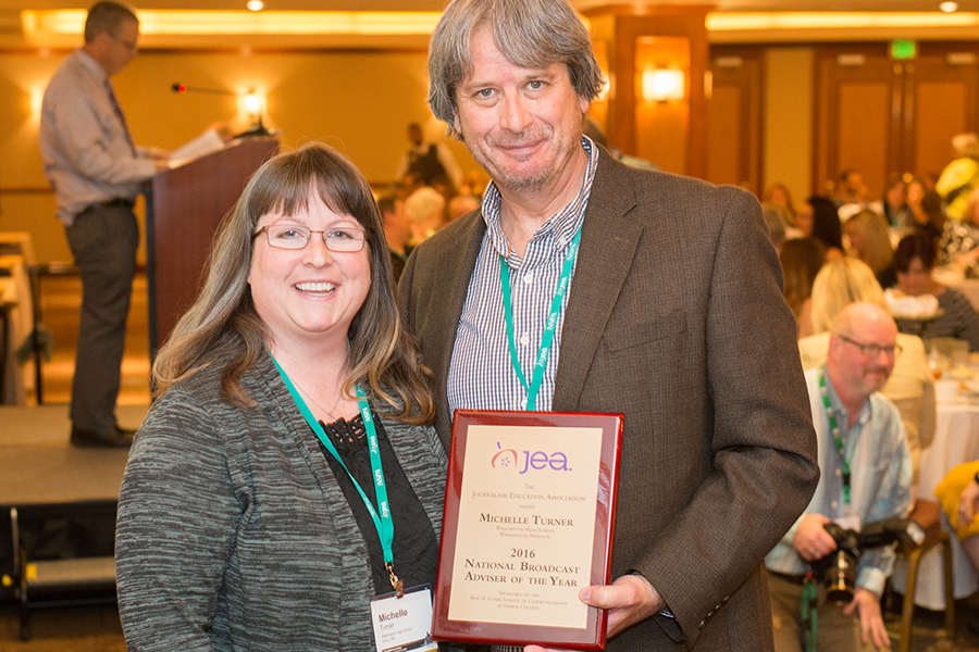 Michelle Tuner receives her 2015 National Broadcast Adviser of the Year plaque from JEA President Mark Newton in Los Angeles.